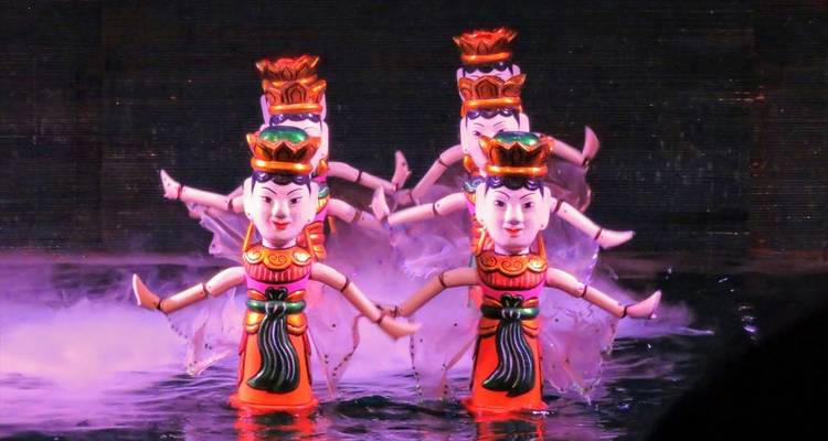 Waterpoppenvoorstelling in een zwak verlichte omgeving.