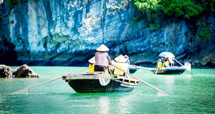 Menschen, die in Booten rudern, umgeben von Klippen