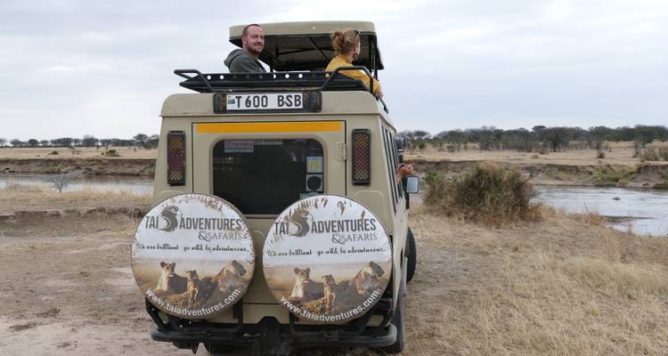 Des gens assis sur le toit d'un véhicule de safari pendant leur exploration.