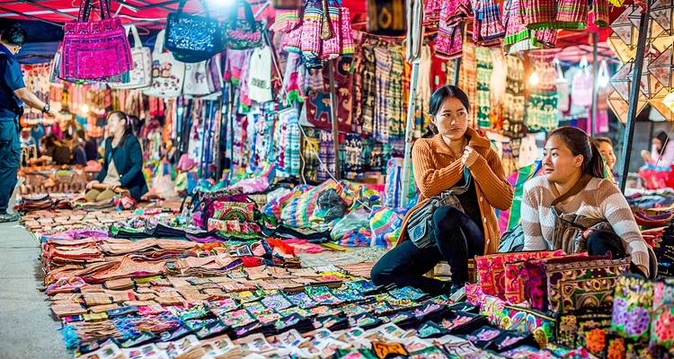 Levendige nachtmarktscène met lokale handwerkproducten en winkelende mensen.