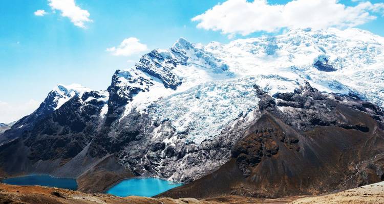 Schneebedeckte Berge mit klaren blauen Seen am Fuß.