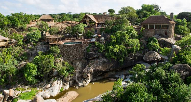 Luxueuze lodges met uitzicht op een weelderig landschap met rotsen.