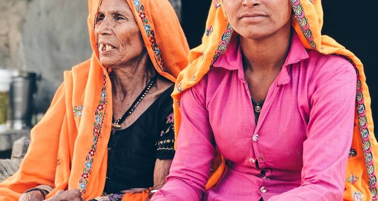 Twee vrouwen in traditionele Indiase kledij die samen zitten.