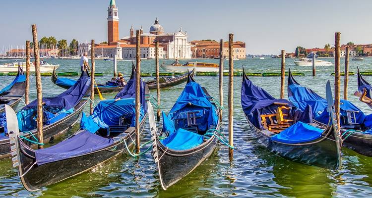 Reihe von Gondeln mit der Kirche San Giorgio Maggiore im Hintergrund.