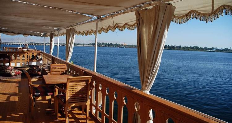 Deck eines Bootes mit Sitzgelegenheiten mit Blick auf einen Fluss.