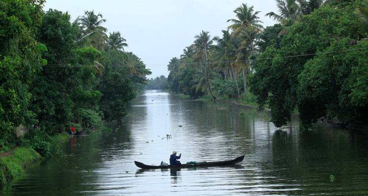 Kleines Kanu auf einem schmalen Wasserweg, umgeben von dichtem Grün.