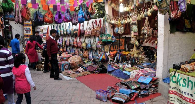 Kleurrijke markt met tassen en textiel uitgestald.