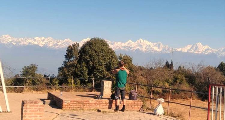 Persona tomando una foto de una cordillera desde un mirador.