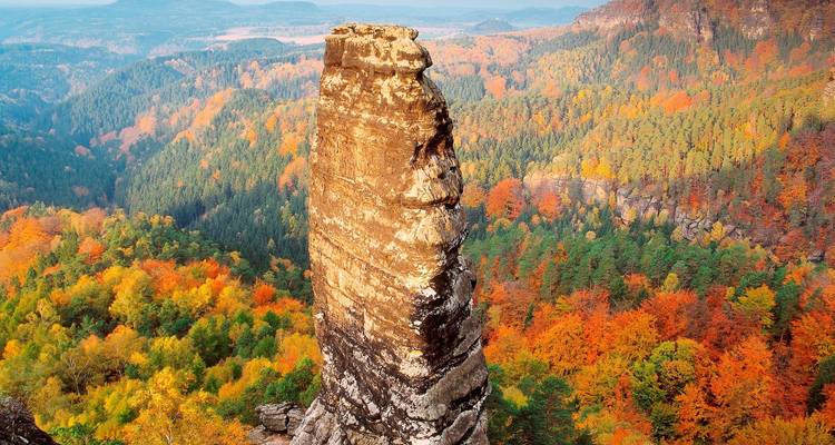 Un seul pic rocheux entouré de feuillage d'automne.