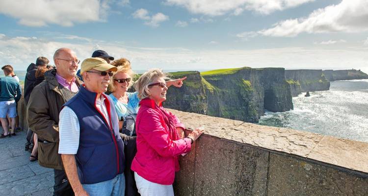 Le groupe touristique profite de vues panoramiques sur l'Atlantique depuis le mur de belvédère des Falaises de Moher.
