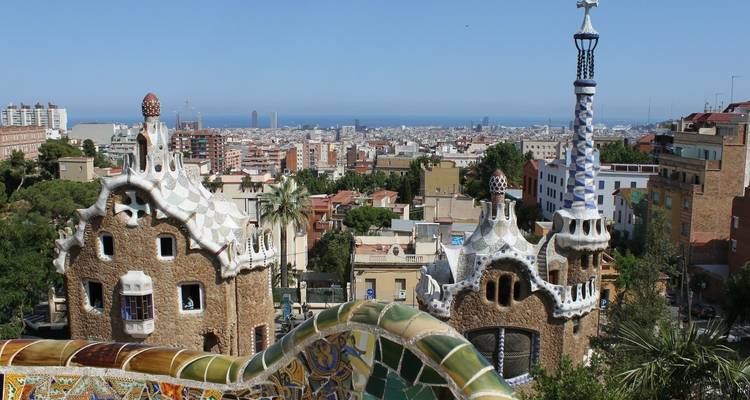 Blick auf den Park Güell mit der Stadtsilhouette von Barcelona im Hintergrund.