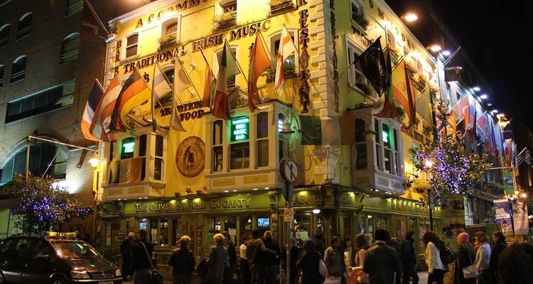 Busy pub in Dublin with flags and people.