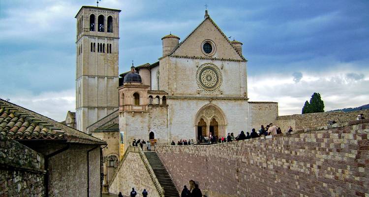 Sint-Franciscusbasiliek in Assisi met bezoekers op een bewolkte dag.