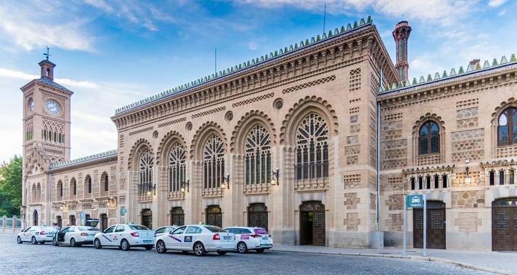 Historisches Gebäude mit Bogenfenstern und einem Uhrenturm.