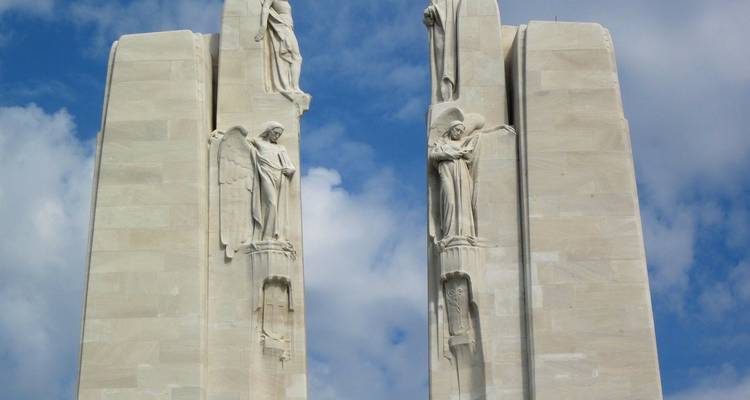 Statuen, die ein großes Denkmal schmücken, mit blauem Himmel.