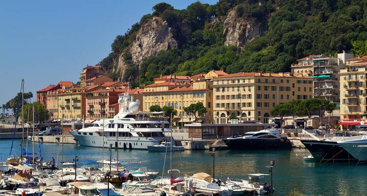 Yachten im Hafen mit Bergen und bunten Gebäuden im Hintergrund.