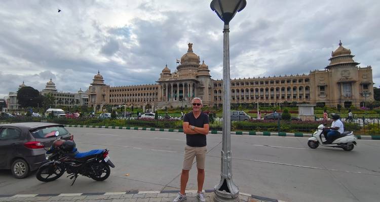 Ein Mann posiert vor einem großen Regierungsgebäude entlang einer belebten Straße.