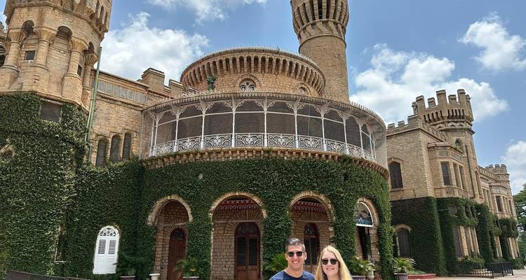 Paar steht vor einem prächtigen historischen Gebäude, das mit Efeu bewachsen ist.