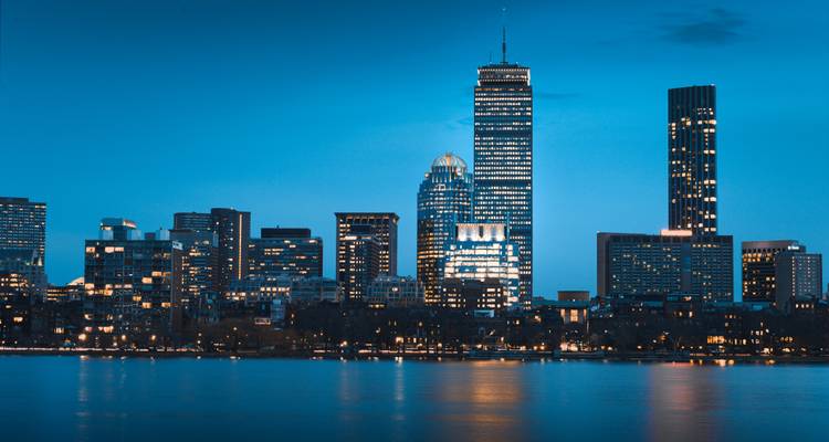 Boston skyline at night with a view across the water.