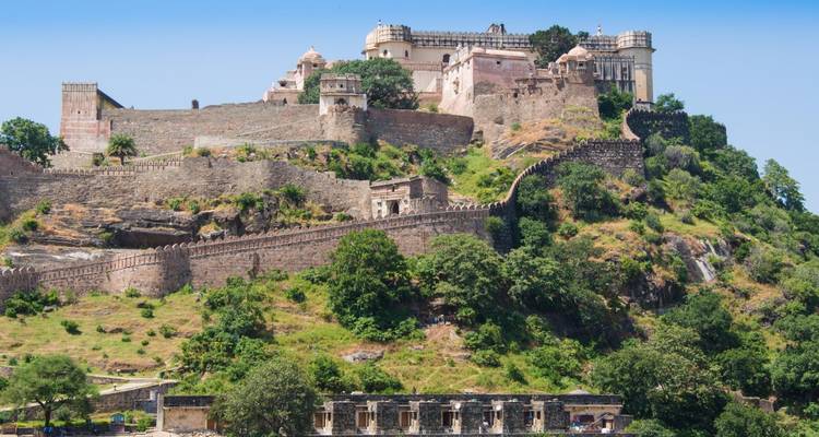 Historische Festung auf einem Hügel, umgeben von Grün.