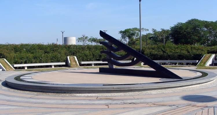 Zonnewijzer sculptuur in een open parkgebied.