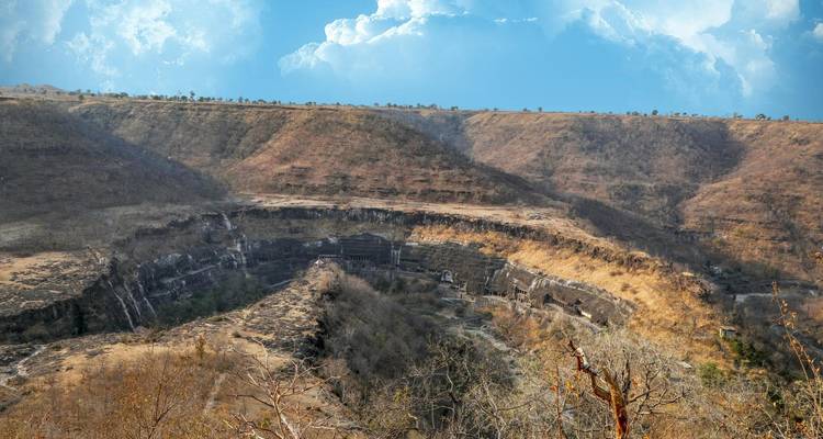Panoramablick auf die Ajanta-Höhlen an einer geschichteten Felswand.