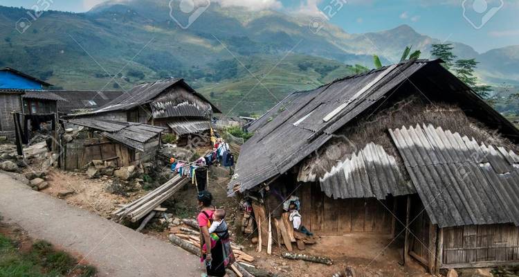 Traditionelle Dorfhäuser mit Bergen im Hintergrund.