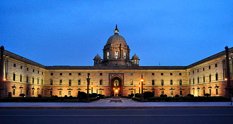 Verlicht overheidsgebouw in New Delhi tijdens de schemering.