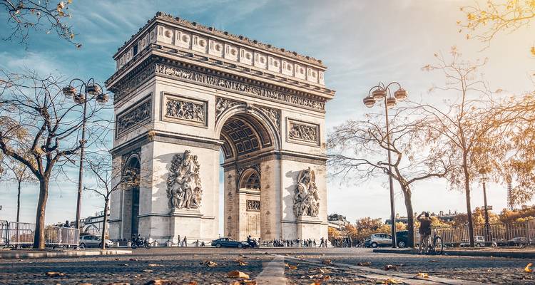 Arc monumental célèbre avec sculptures et arbres environnants.