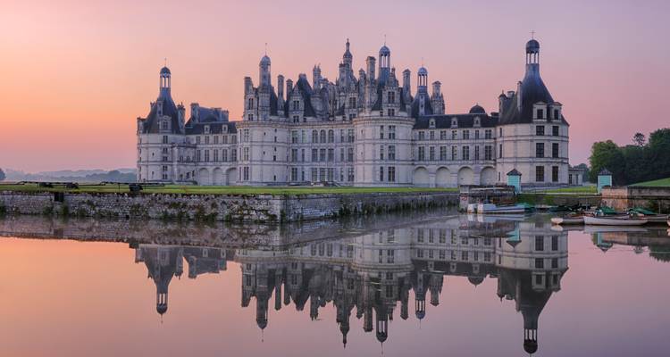 Château orné avec reflet dans l'eau au coucher du soleil.