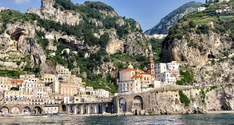 View of Amalfi Coast with rocky cliffs and buildings by the sea.