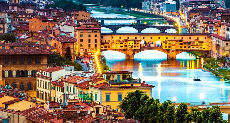 Aerial view of Ponte Vecchio bridge in Florence lit up in the evening.