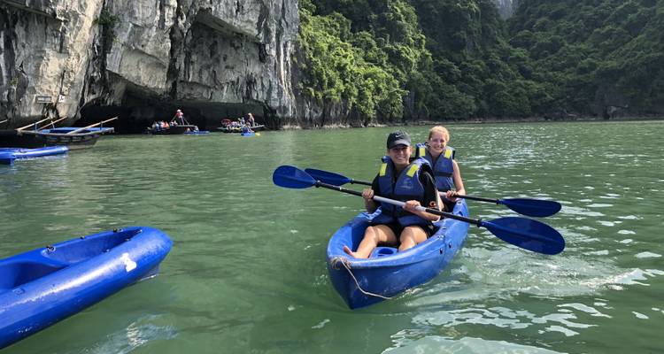 Menschen beim Kajakfahren in einer malerischen Bucht.