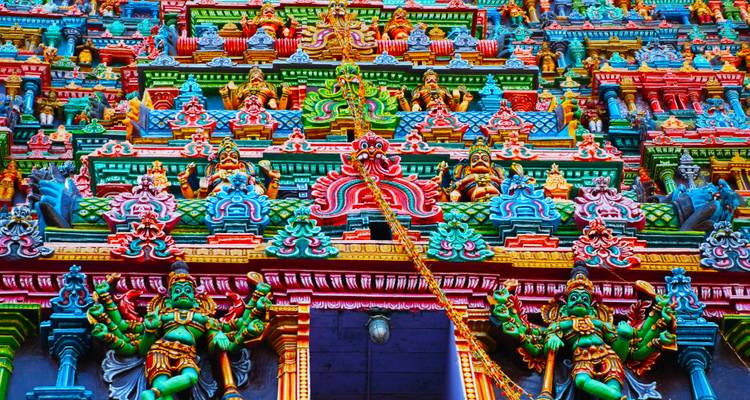 Ein lebendiger und farbenprächtiger Tempel-Gopuram, der mit Avataren und Gottheiten geschmückt ist.