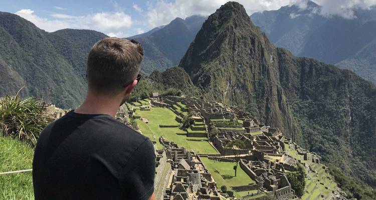 Persoon die naar Machu Picchu in de verte kijkt.