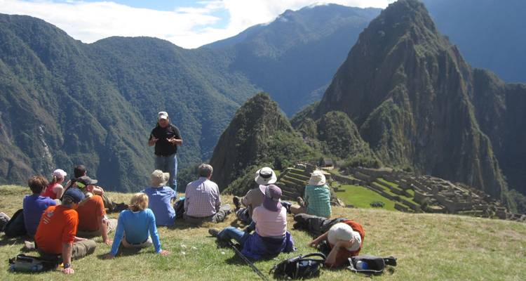 Rondleidingsgroep met een gids die uitkijkt over Machu Picchu.
