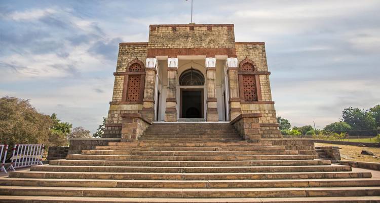 Historisch gebouw met trappen die omhoog leiden, heldere lucht.