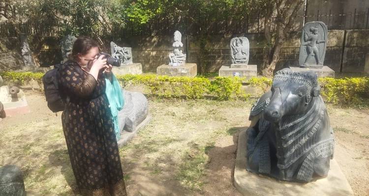 Vrouw fotografeert beelden in een buitentuin.