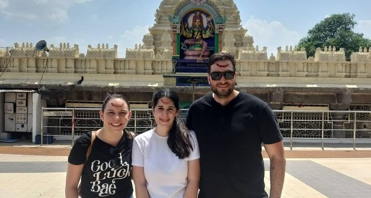 Een groep poseert voor een tempel met sierlijke beeldhouwwerken.