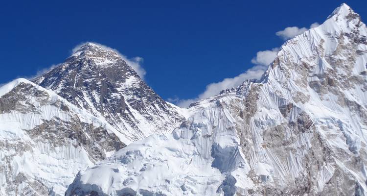 Weite Aussicht auf schneebedeckte Berge unter einem klaren blauen Himmel.