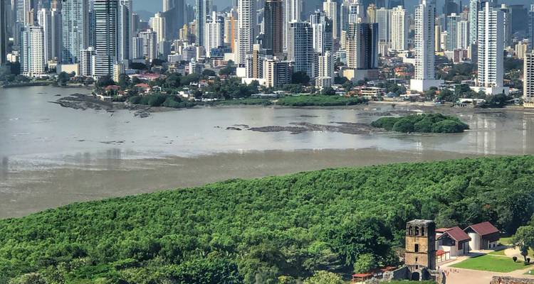 Vue aérienne des mangroves luxuriantes, des ruines coloniales et de la skyline moderne de Panama à travers la baie.