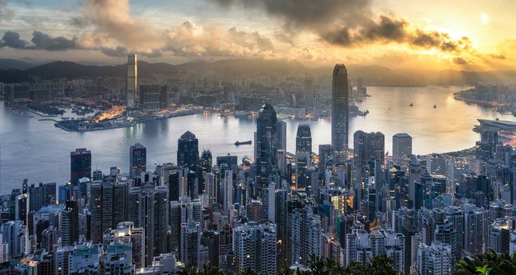 Vista panorámica del horizonte de Hong Kong con un puerto durante el atardecer.