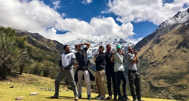 Group of hikers posing with mountains in the backdrop.