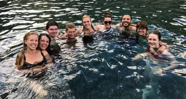 Group of people swimming in a natural pool.