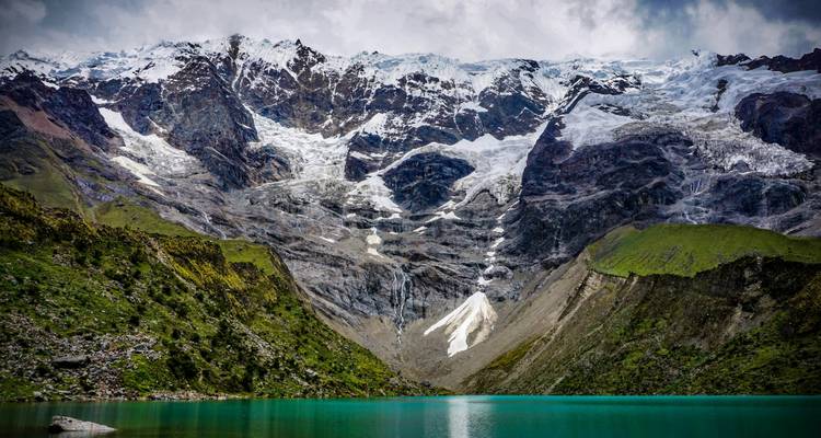 Glacier-fed lake with snow-capped peaks in the background.