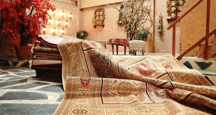 Exhibición de lujosas alfombras de estilo persa colgadas por todo el piso de una tienda encantadora.