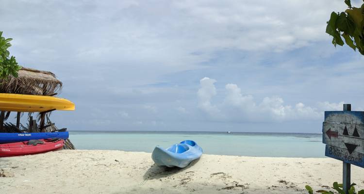 Ein ruhiger Strand mit einem Kajak auf dem Sand.