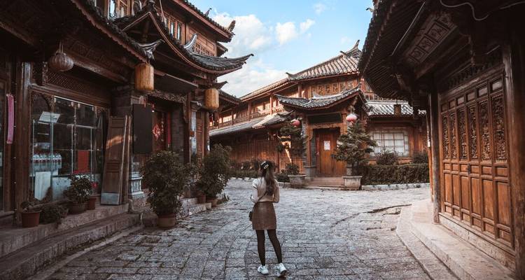 Woman standing in an ancient, traditional Asian street.