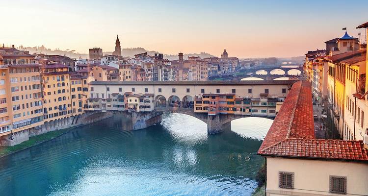 Ponte Vecchio avec reflets sur la rivière au coucher du soleil.