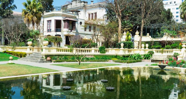 Los reflejos de la elegante arquitectura colonial brillan en el estanque de un jardín formal.